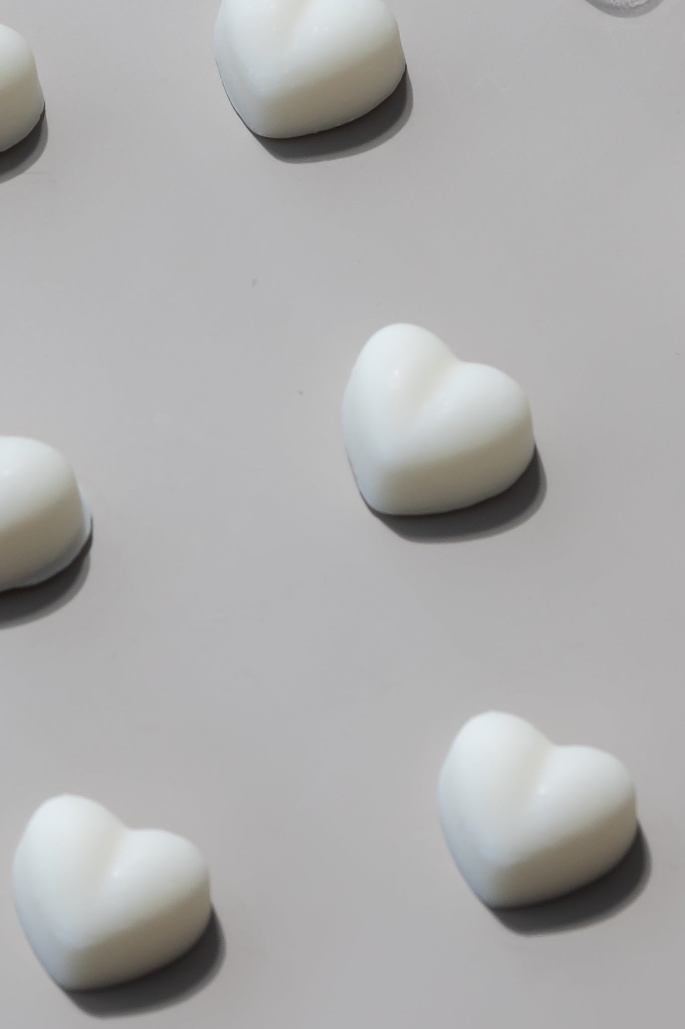 Heart shaped wax melts aligned on neutral background